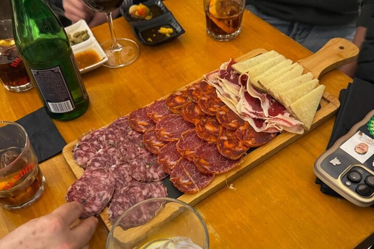 a table with a sandwich and some meats on a cutting board