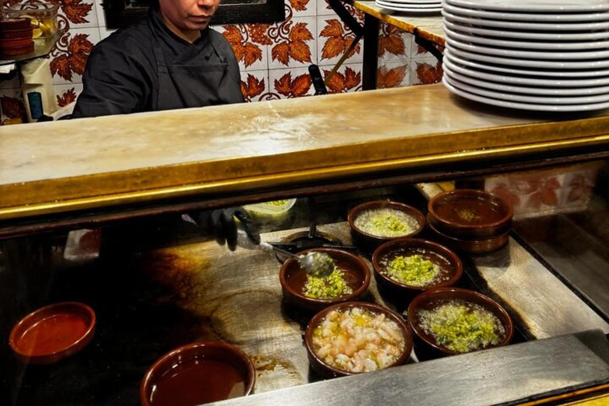 a man standing in a kitchen with bowls of food