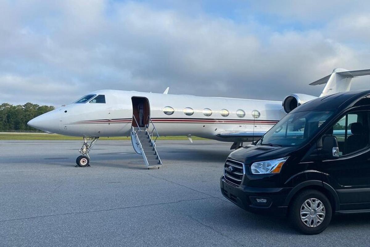 un'auto parcheggiata accanto a un aereo su una pista