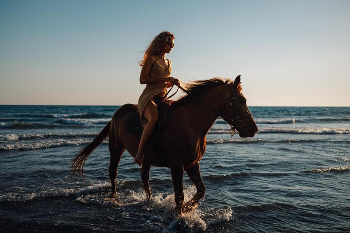 una donna a cavallo sulla spiaggia