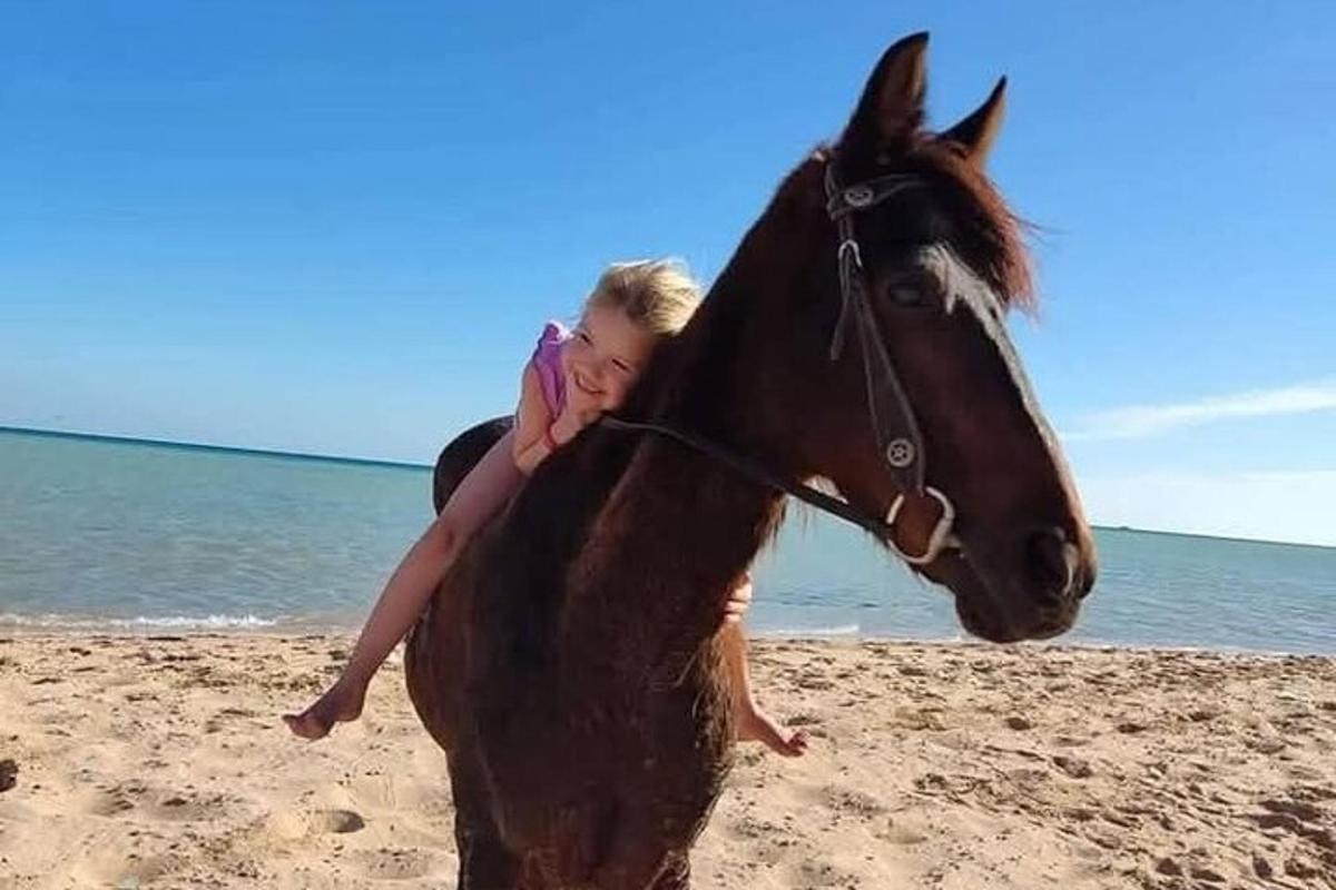 noor tüdruk rannas hobuse seljas ratsutab