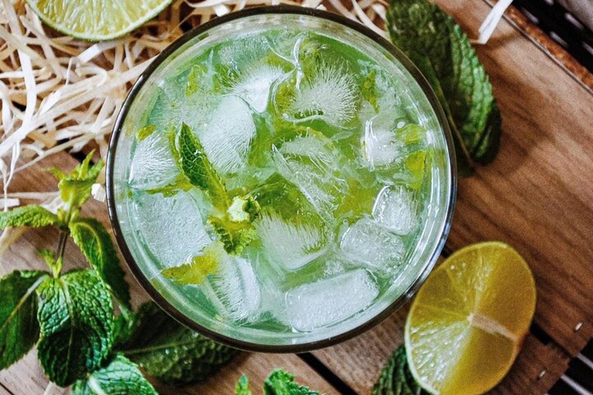 ein Getränk mit Minze und Limette auf einem Holztisch