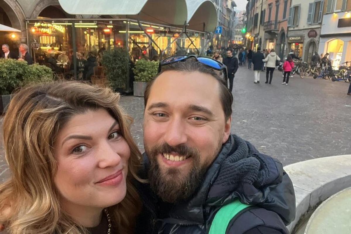 a man and a woman posing for a picture on a street