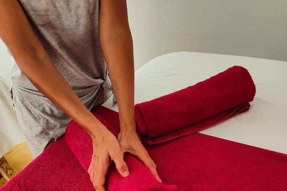 een persoon die een rood stuk stof op een bed knipt