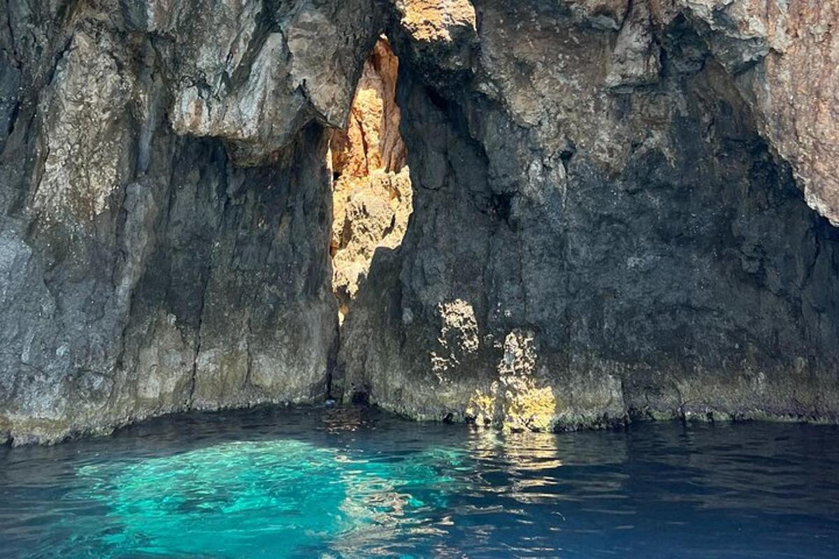 uno specchio d'acqua vicino a una scogliera rocciosa
