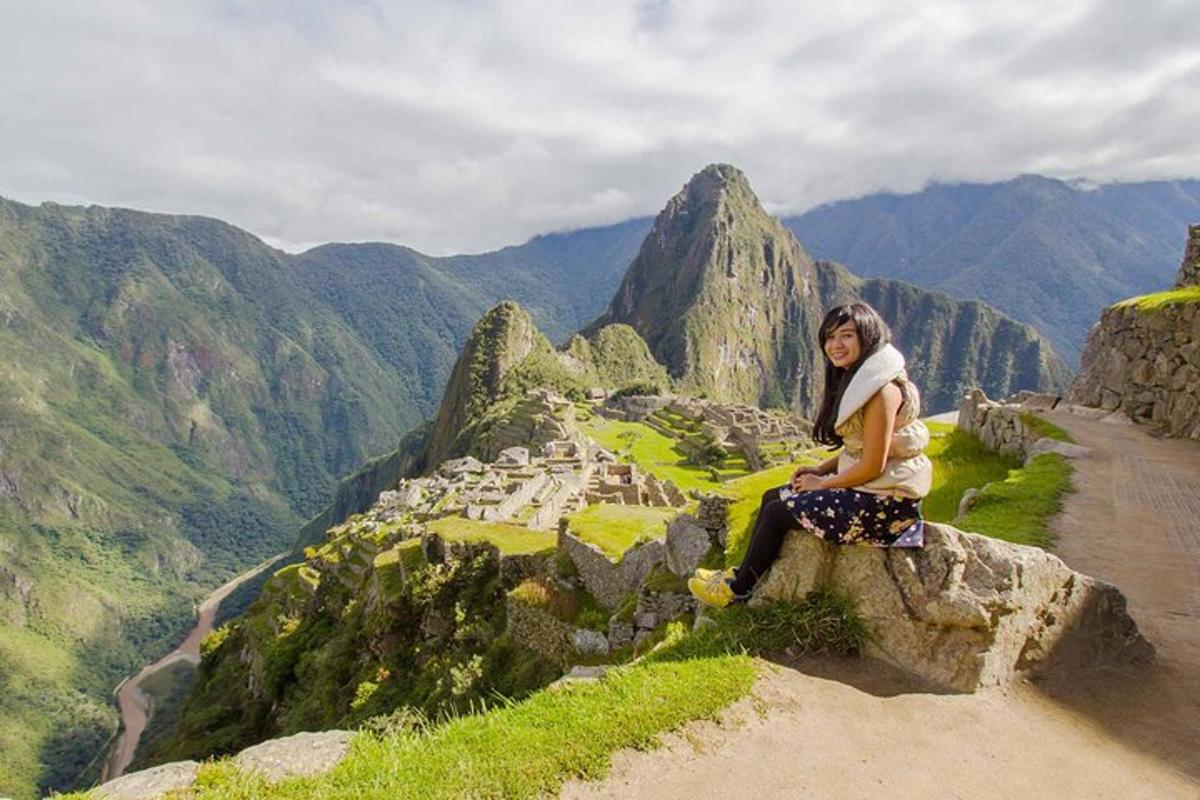 seorang wanita duduk di atas batu di atas gunung