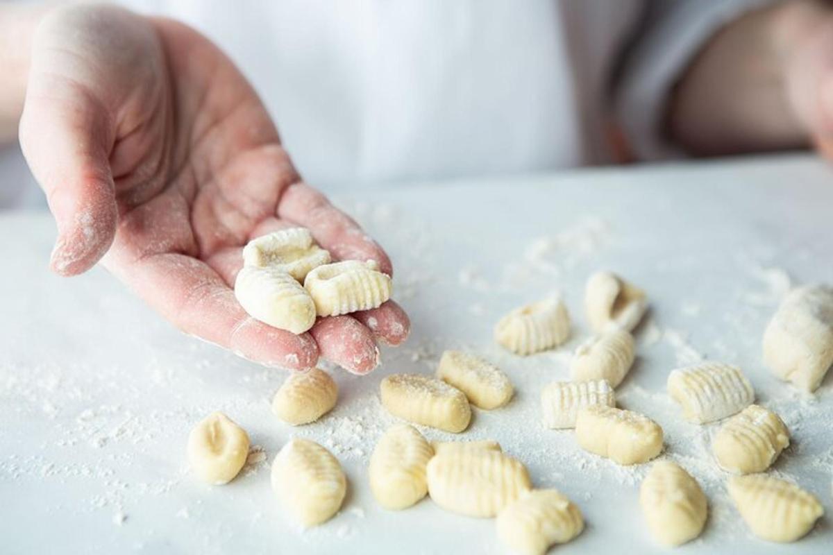 una mà sostenint un manat de pasta