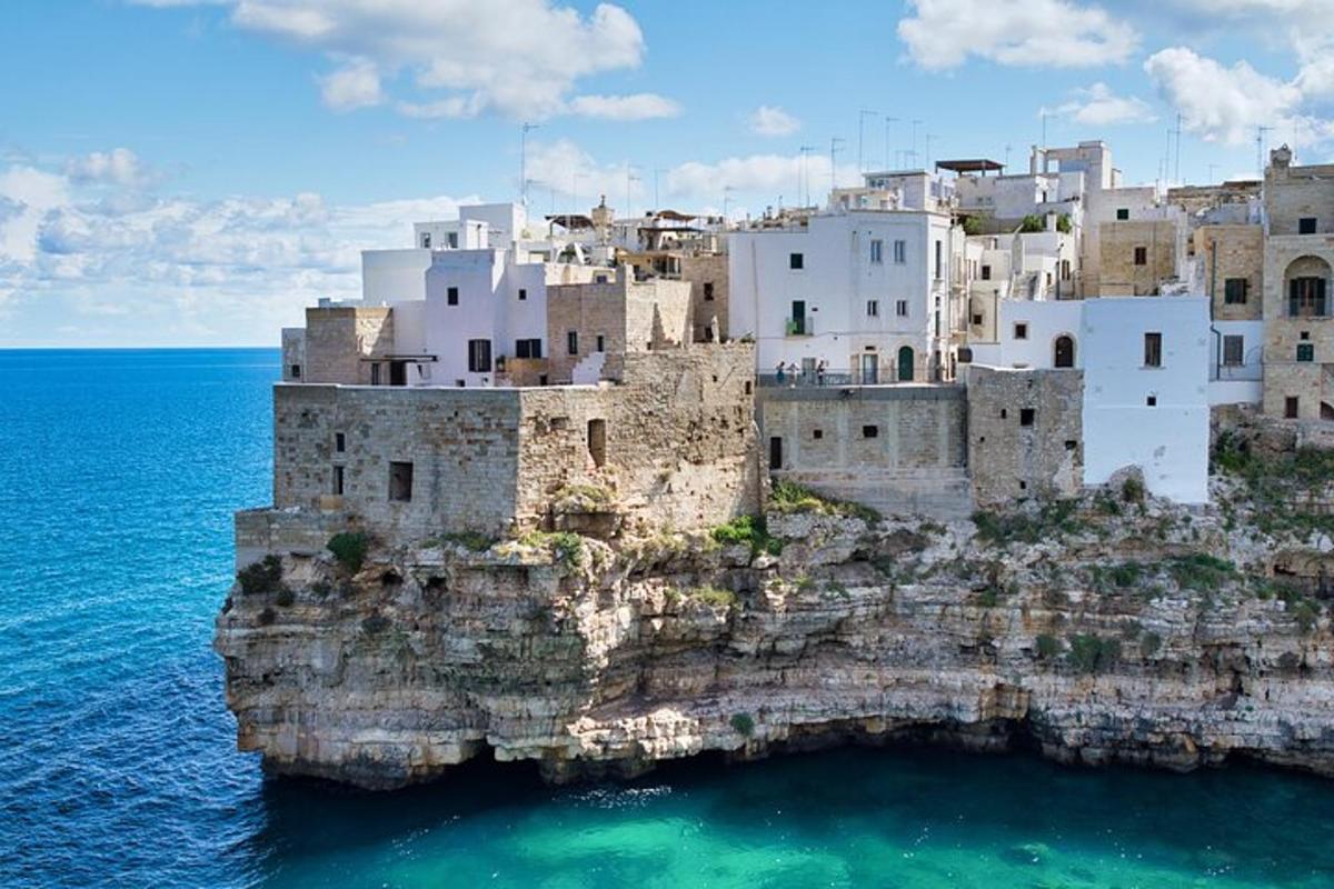 a group of buildings on top of a rocky island in the ocean