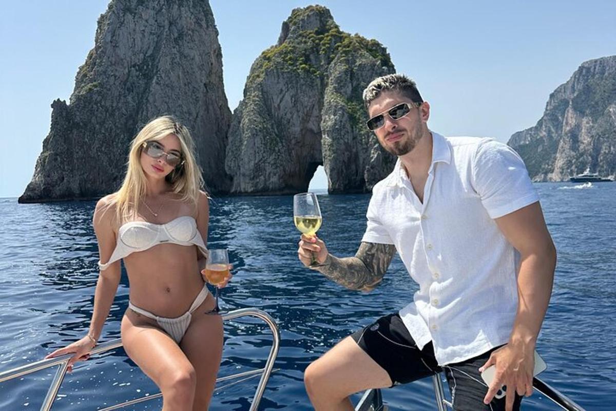 a man and woman on a boat with a glass of wine