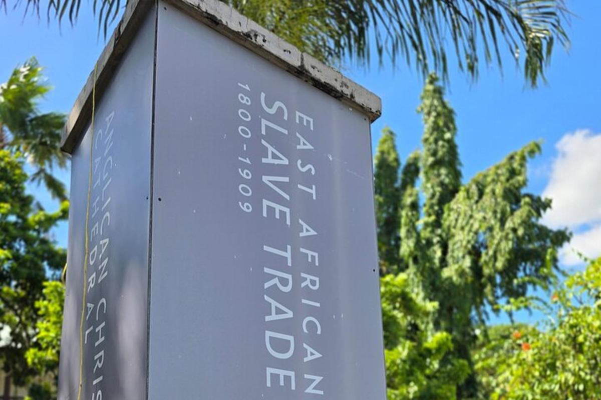 a sign for a park with trees in the background