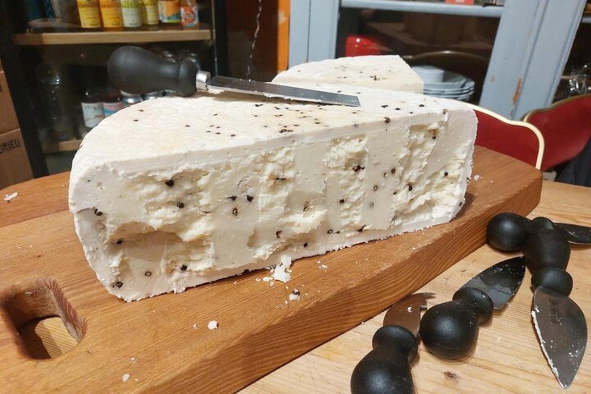 un pezzo di formaggio su un tagliere con un coltello