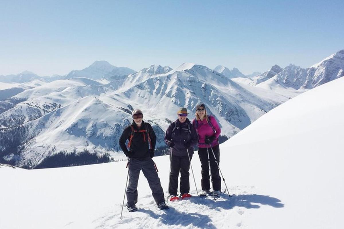 three people standing on top of a snow covered mountain