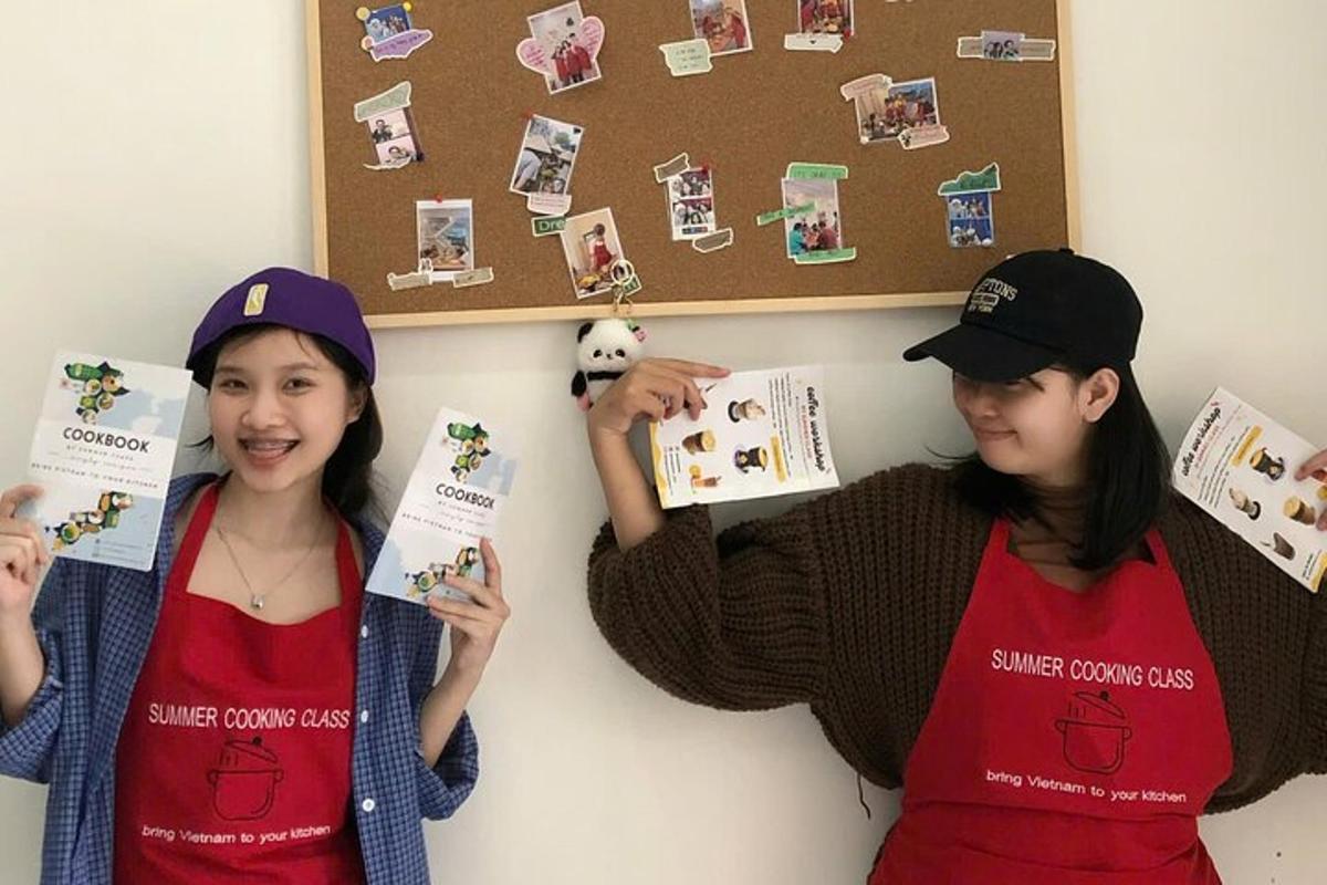 two girls are holding up cards on a wall