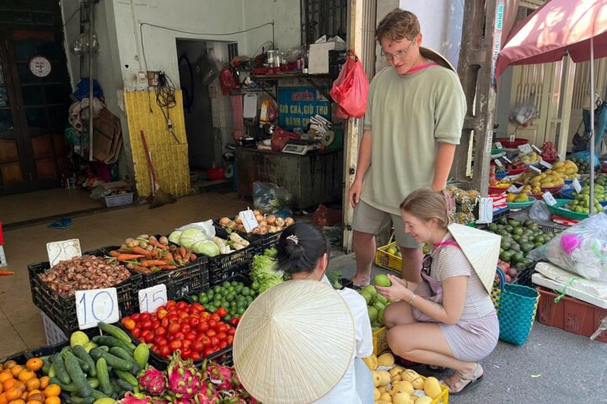 a group of people sitting in a market with fruits and vegetables