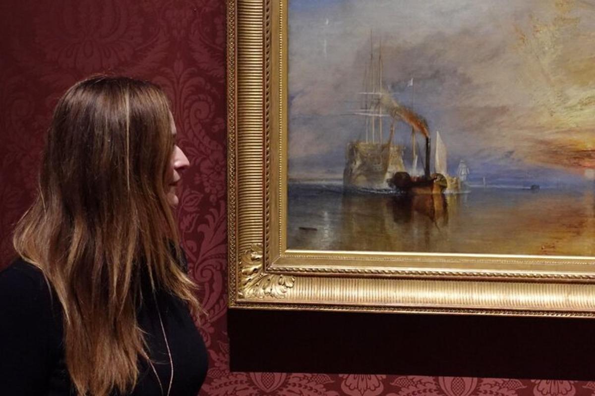 μια γυναίκα που στέκεται δίπλα σε έναν πίνακα που απεικονίζει μια βάρκα