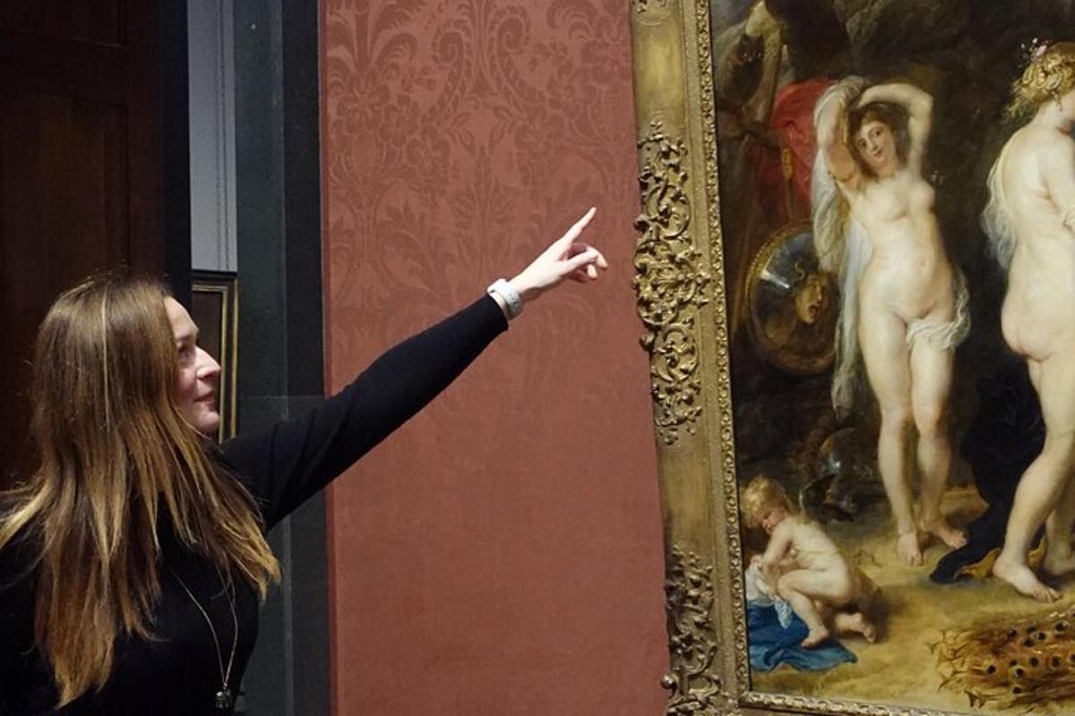 uma mulher apontando para uma pintura em um museu