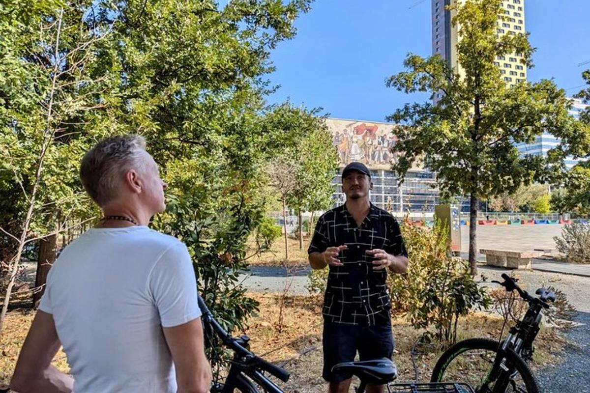 un uomo in piedi accanto a un uomo con una bicicletta