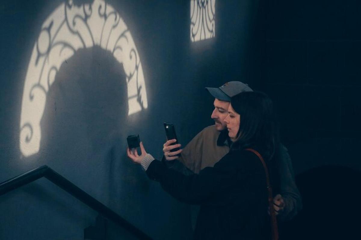 Un hombre y una mujer mirando sus teléfonos celulares.
