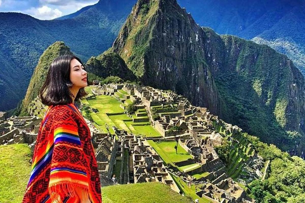 una donna in piedi sulla cima di una montagna che guarda una città