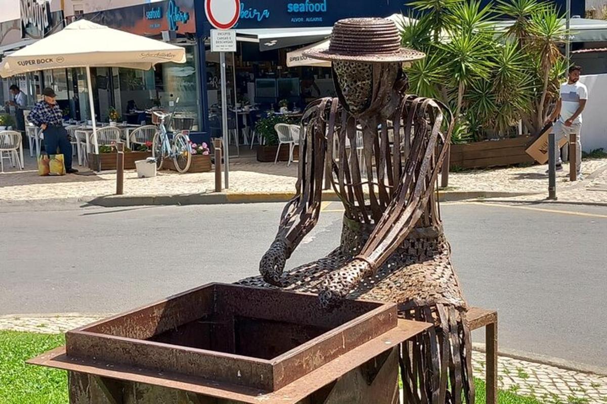 en statue av en mann med hatt som sitter i en eske