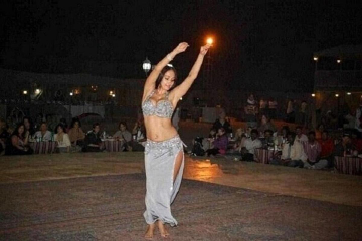 žena stojící na tanečním parketu s rukama ve vzduchu