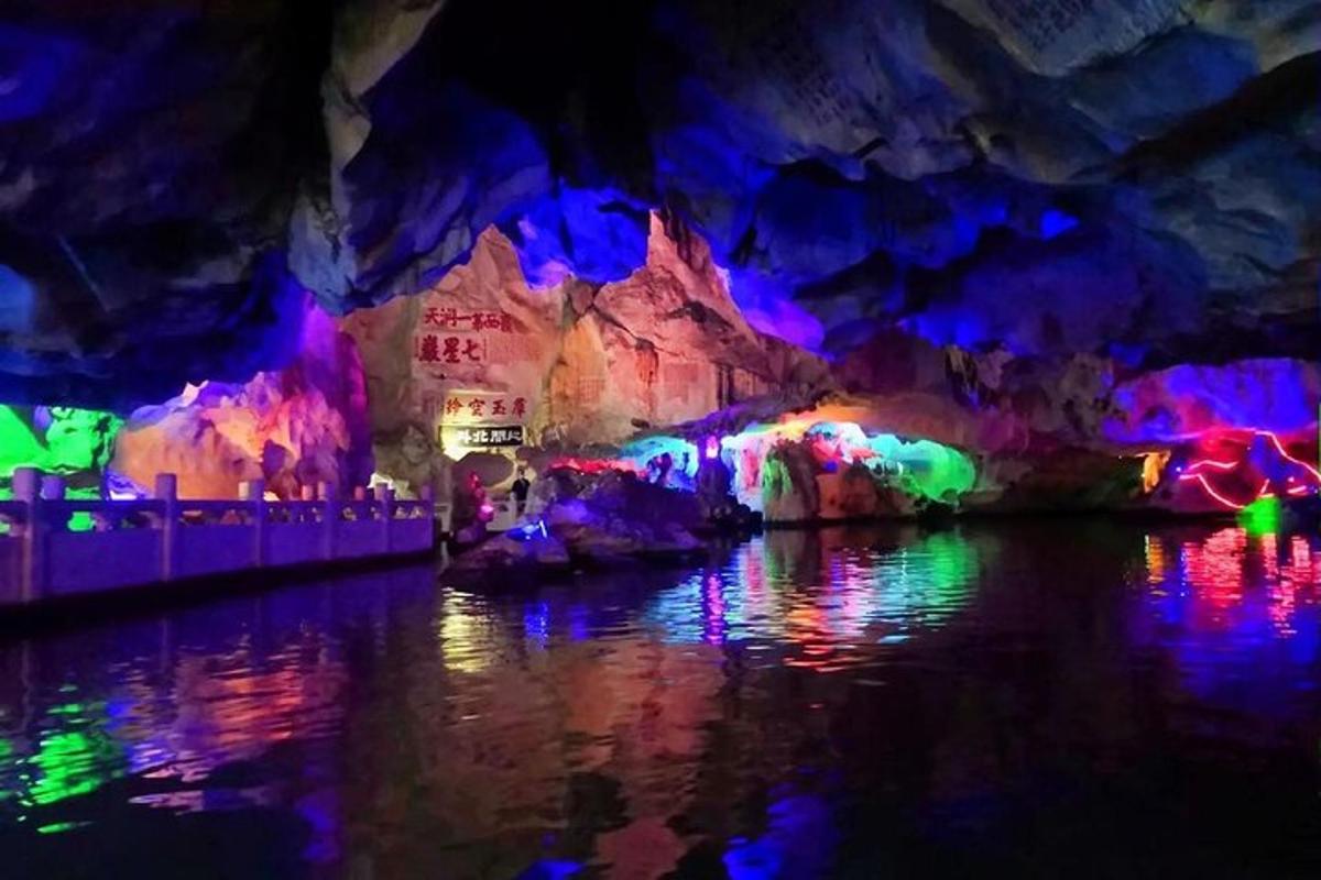 a cave with colorful lights on the water