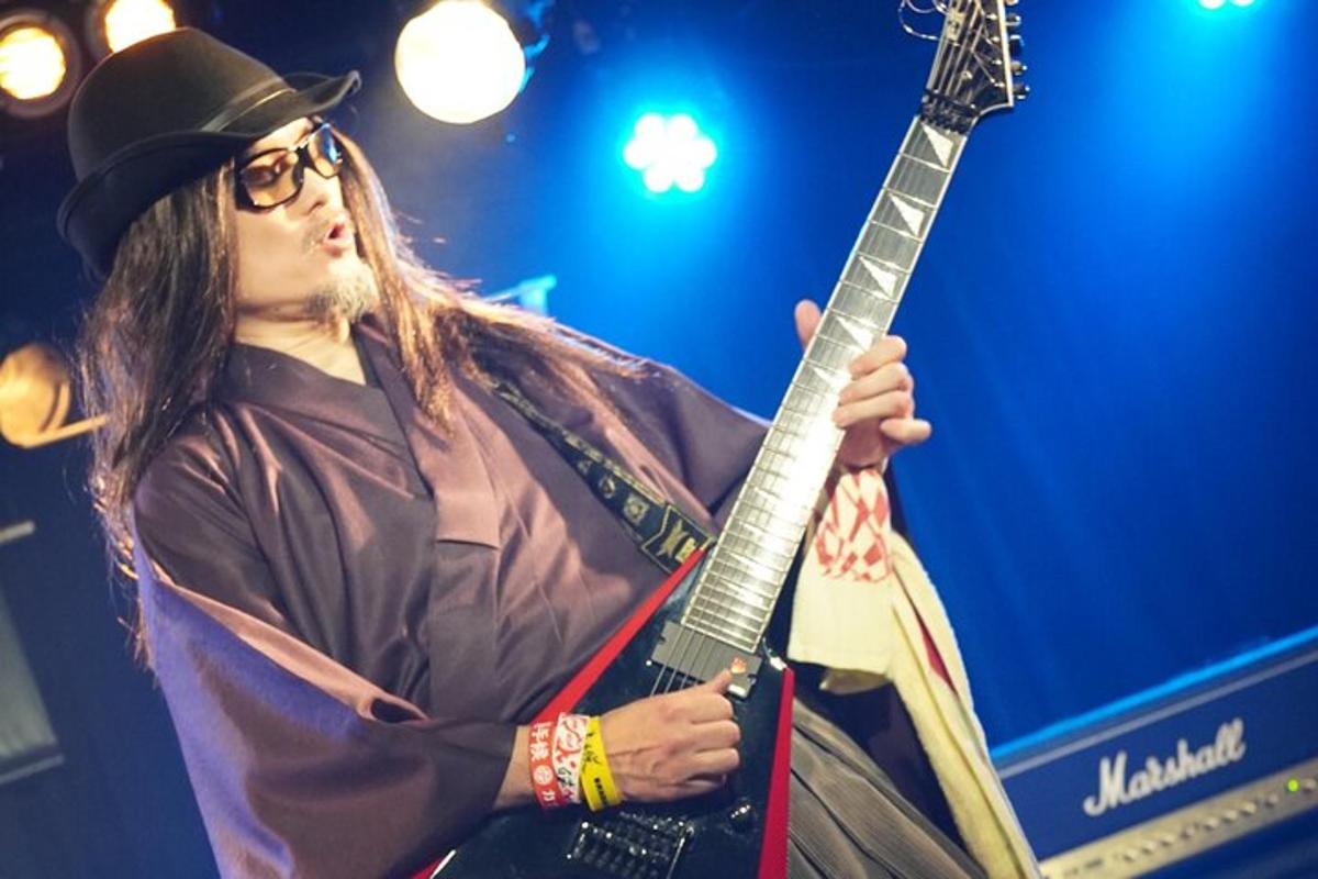 seorang lelaki memegang gitar di atas pentas