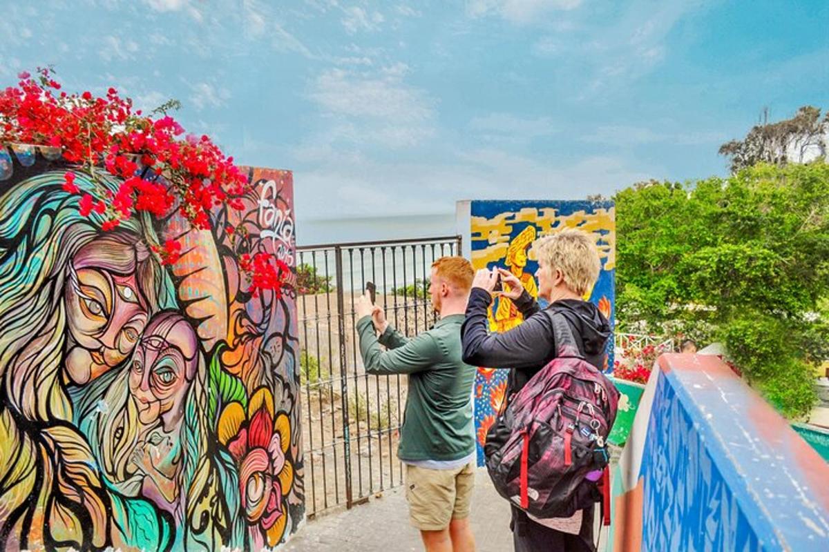 dua orang mengambil gambar mural berwarna-warni
