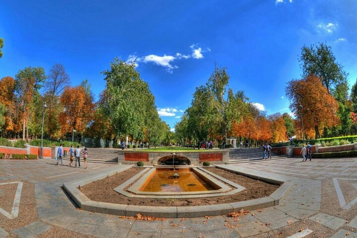 isang fountain sa isang parke na may mga taong naglalakad sa paligid nito