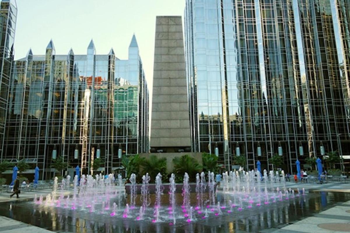 a water fountain in front of some tall buildings