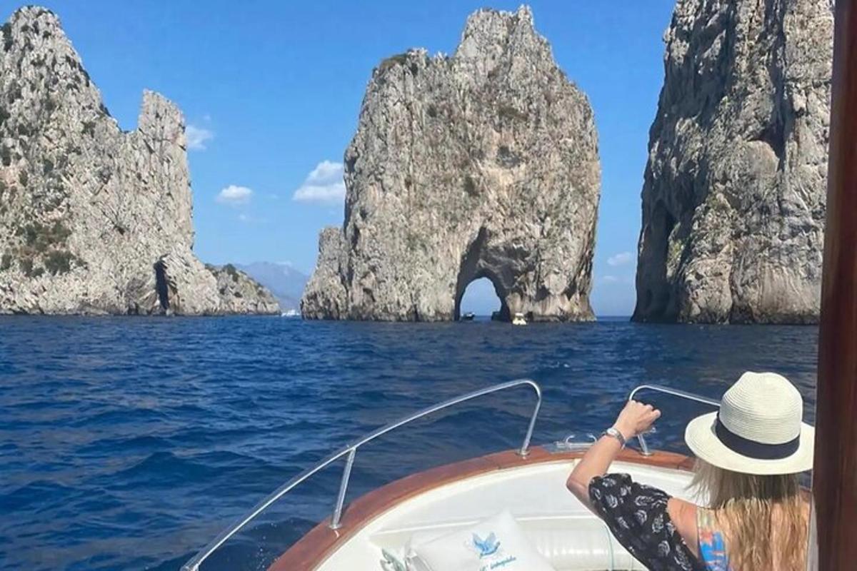 Μια γυναίκα σε μια βάρκα στο νερό με σχηματισμούς ασβεστόλιθου