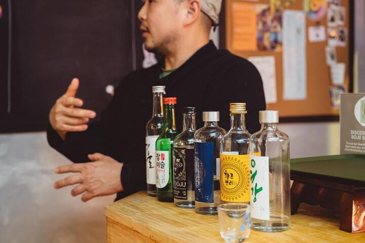 moški, ki kaže palec gor poleg steklenic alkohola