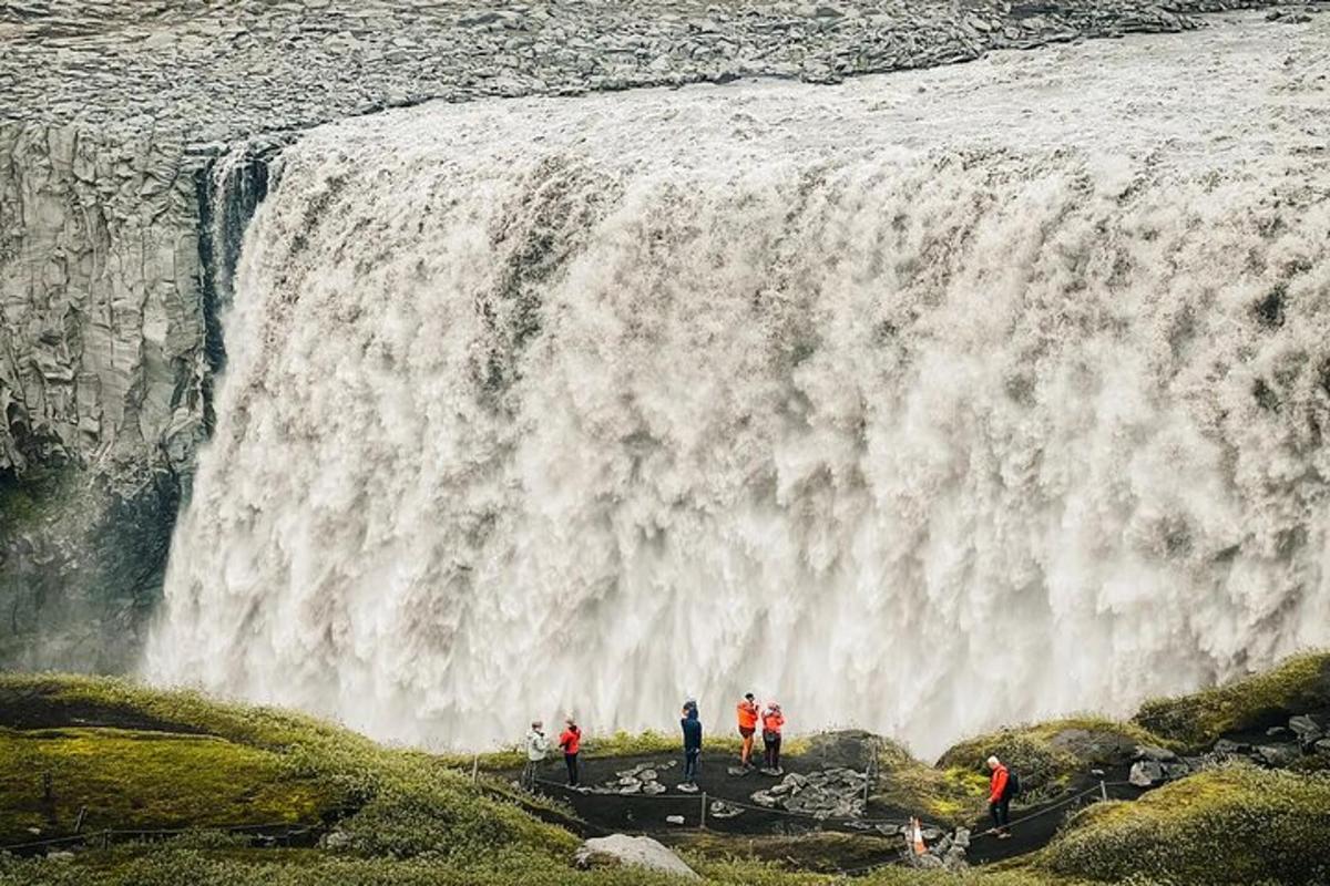 sekumpulan orang berdiri di hadapan air terjun