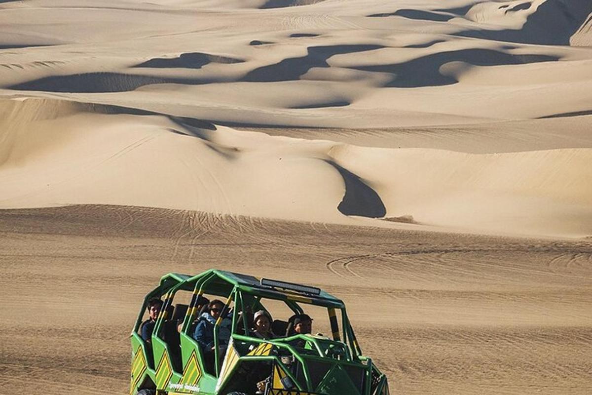 a group of people riding in a green vehicle in the desert