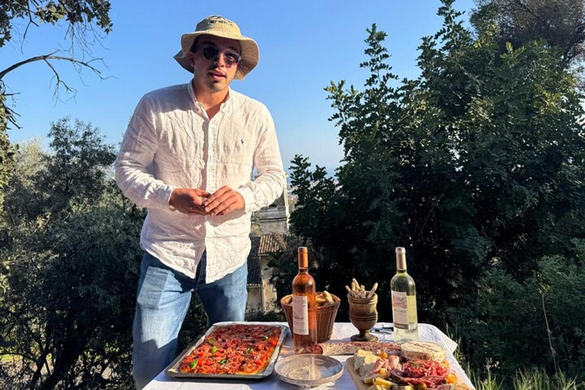 ένας άντρας που στέκεται δίπλα σε ένα τραπέζι με φαγητό και κρασί