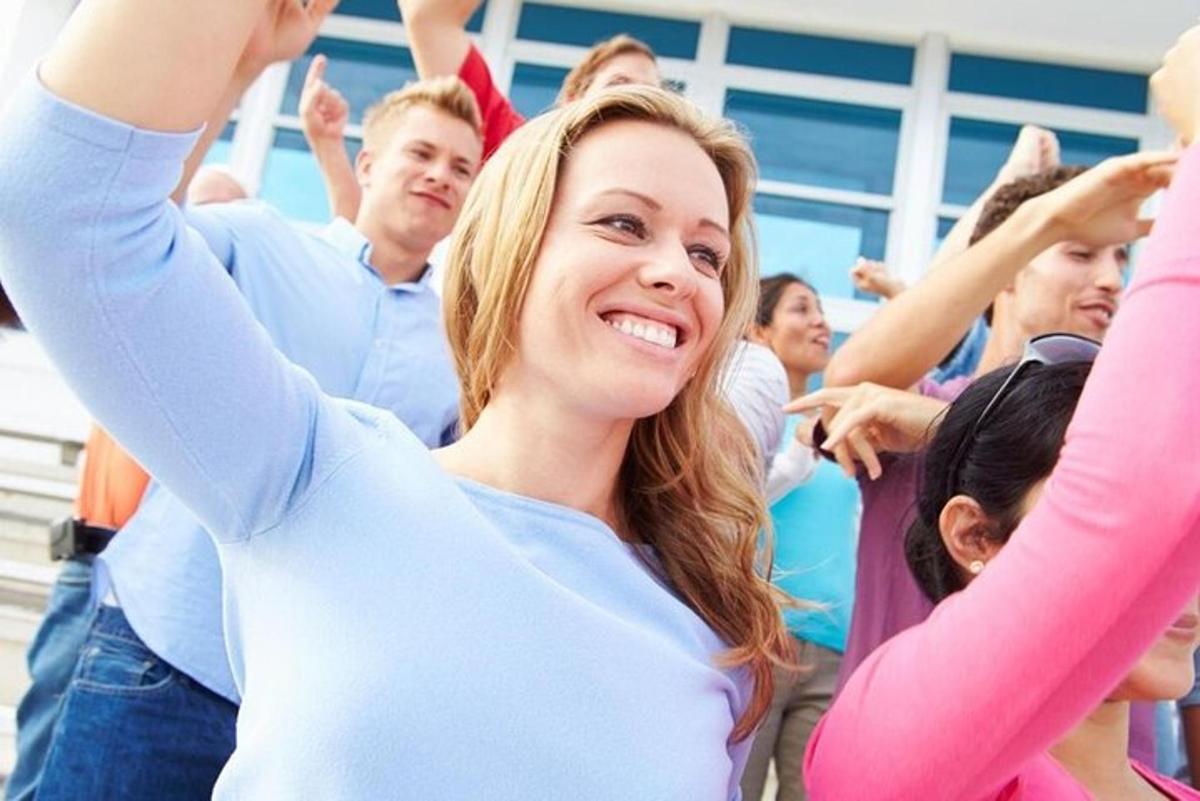 una donna in mezzo a una folla di persone che applaudono