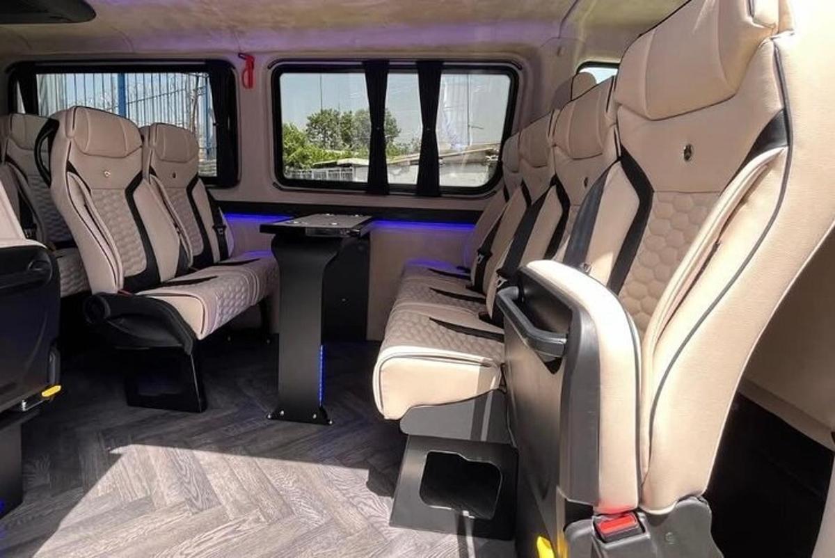 một chiếc xe buýt có ghế trống và một cái bàn trong đó