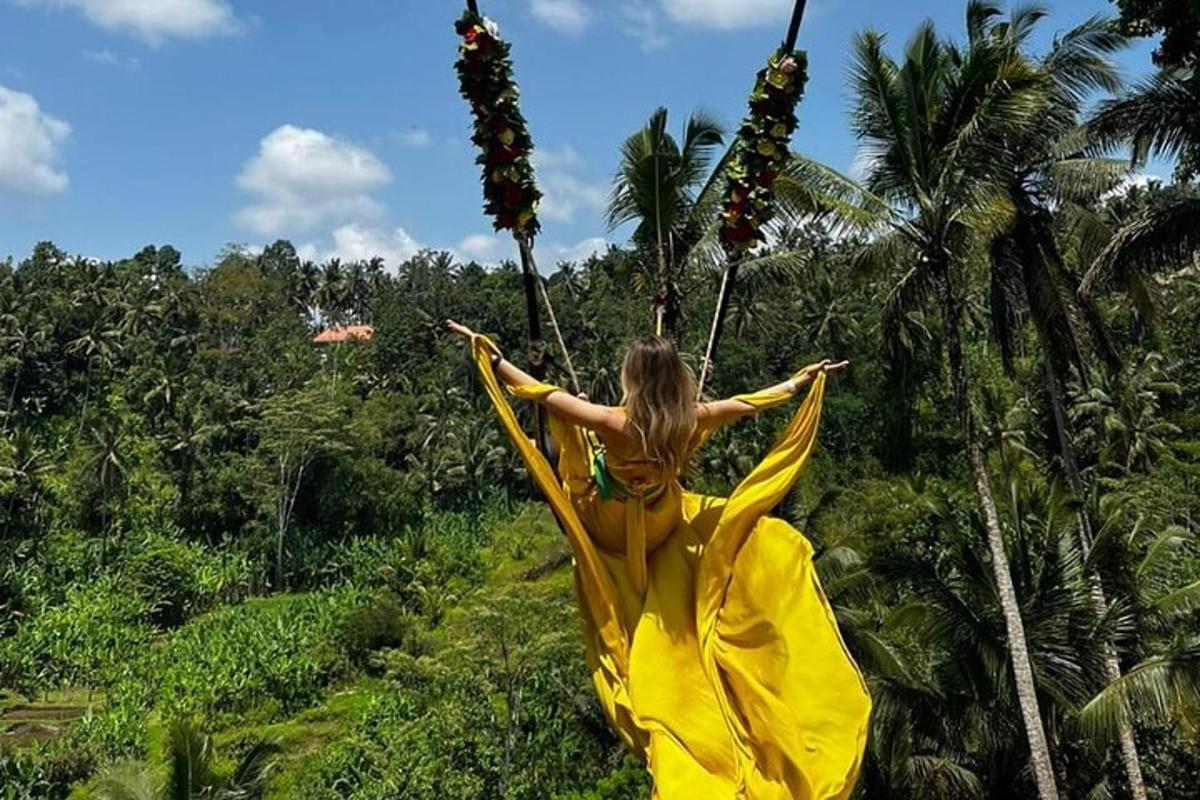 a woman in a yellow dress hanging from a tree