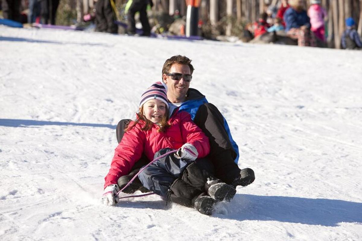 um homem e uma menina sentados na neve