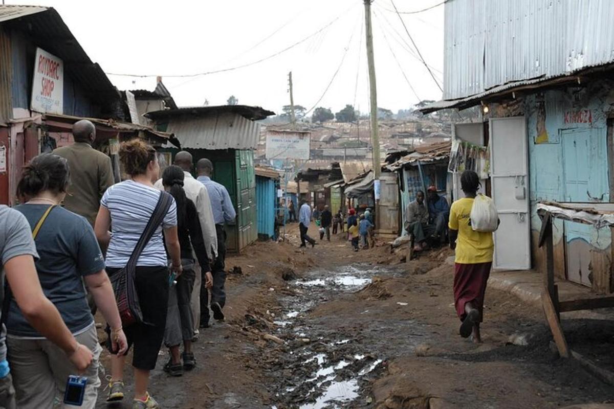 un gruppo di persone che camminano lungo una strada fangosa