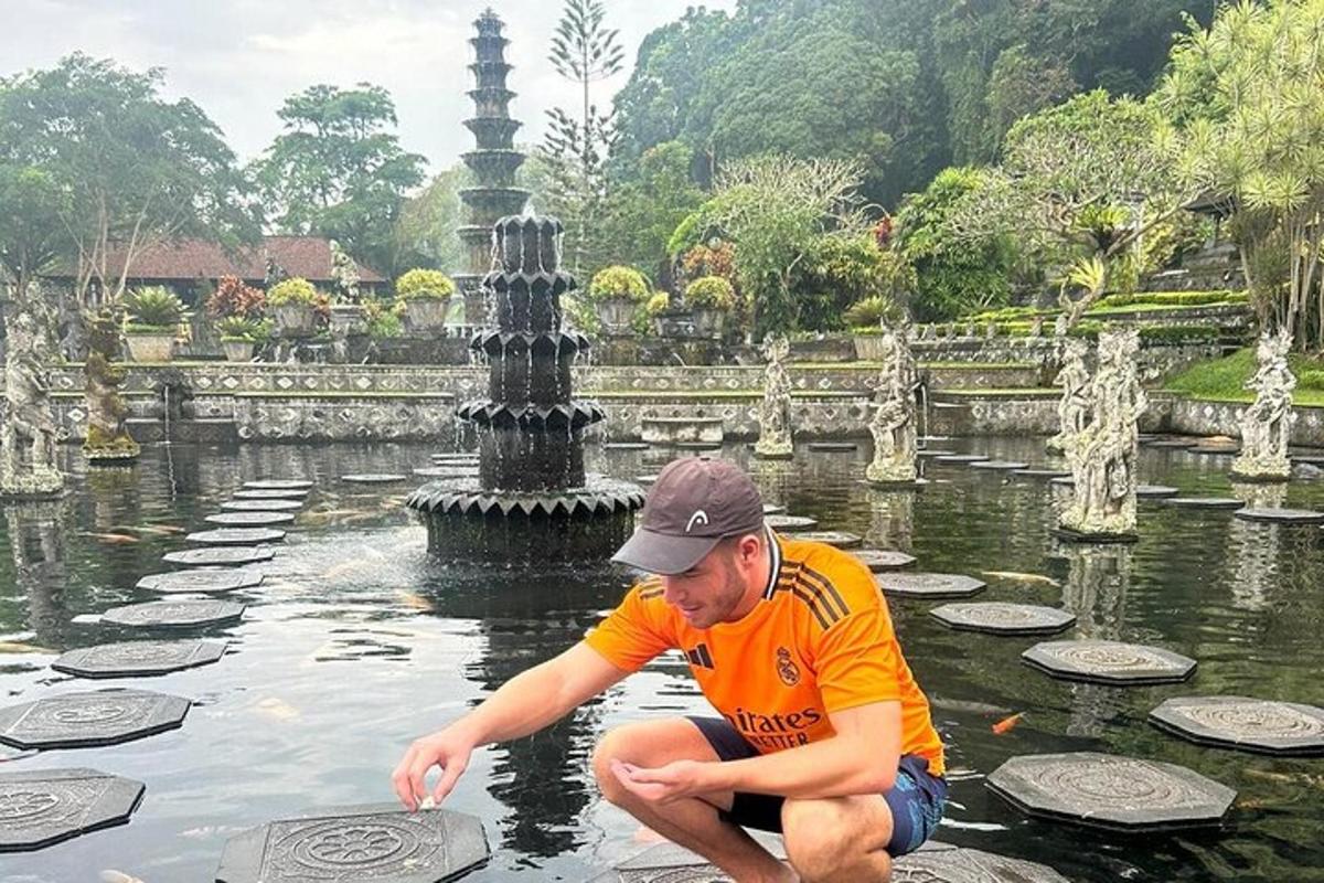 seorang lelaki melutut di dalam air di hadapan mata air