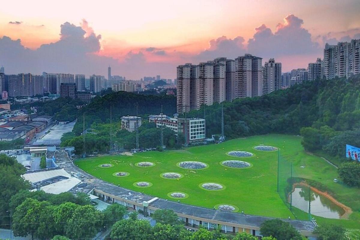a large grassy field with a city in the background