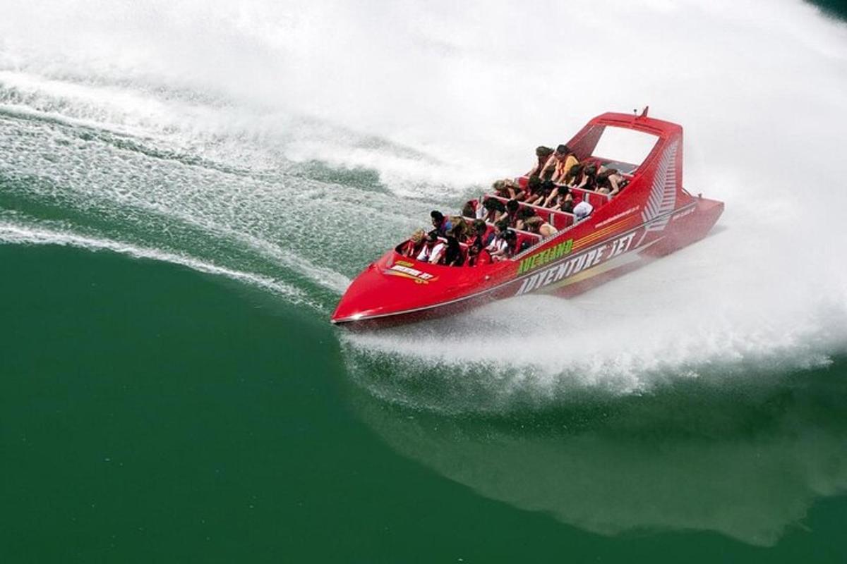 um grupo de pessoas em um barco vermelho na água
