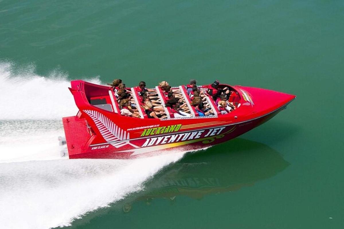 Un grupo de personas en un bote rojo en el agua.