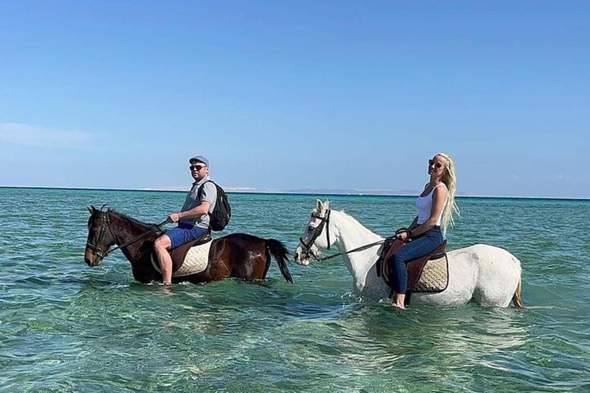 muž a žena jedoucí na koních v oceánu