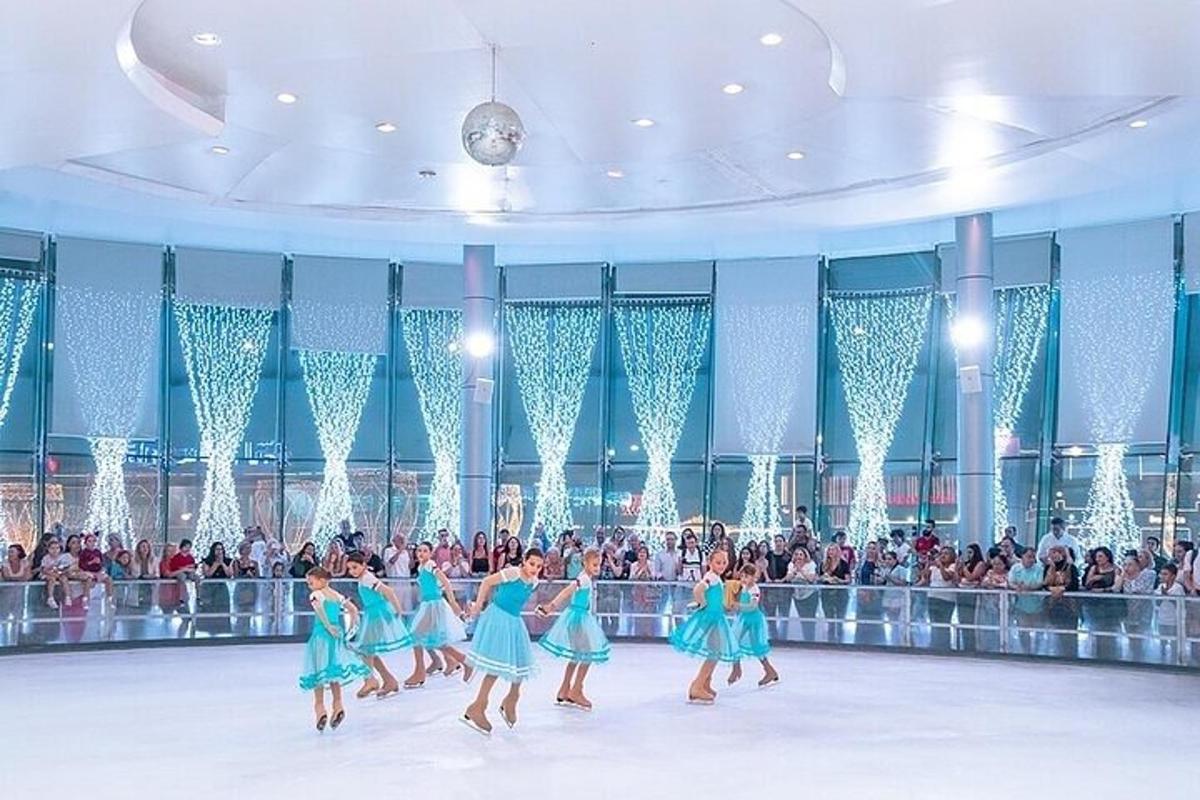 Hópur stúlkna í bláum kjólum dansa fyrir framan mannfjölda