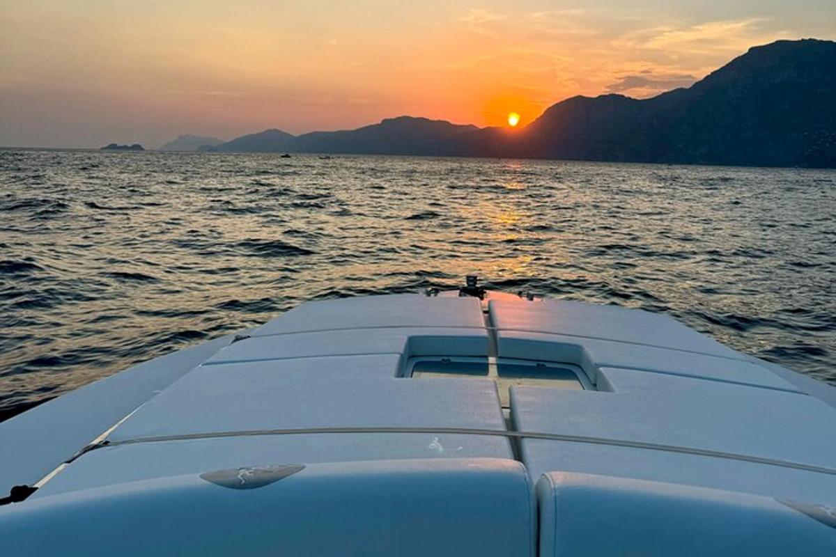 un bateau dans l'eau avec le coucher de soleil en arrière-plan