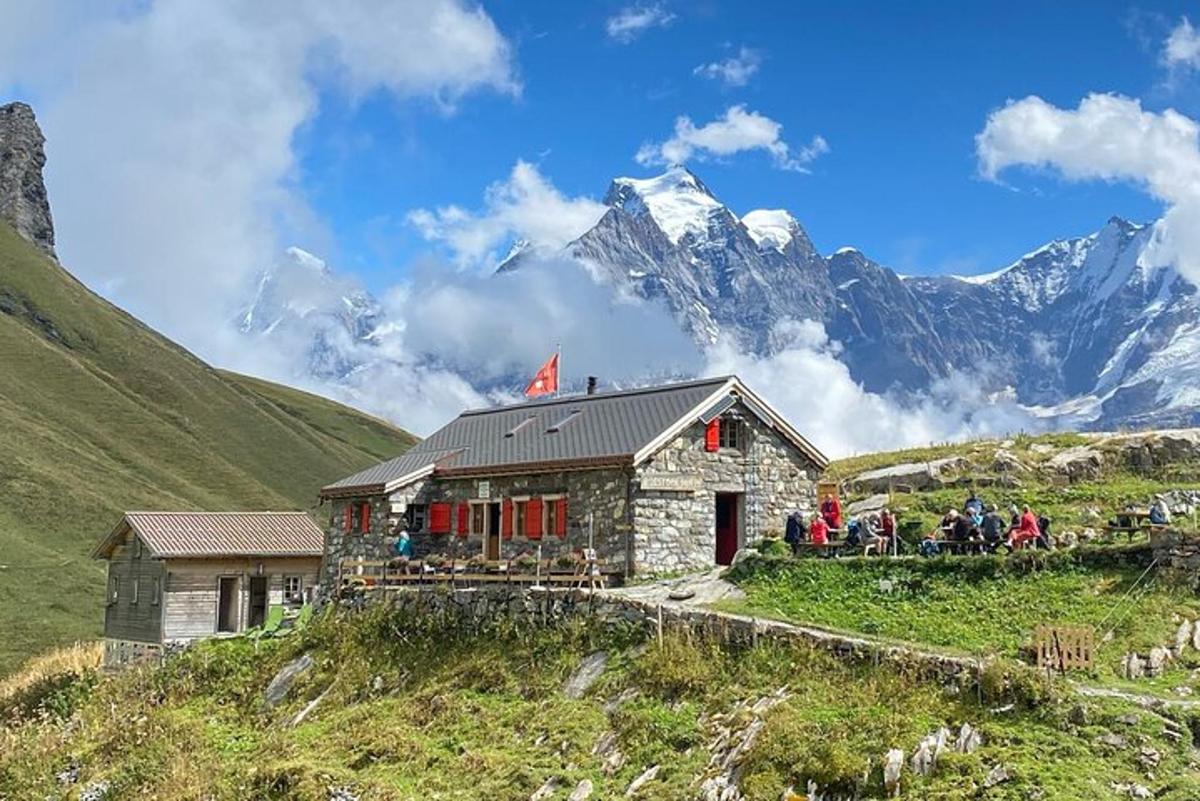 a group of people standing outside of a building on a mountain