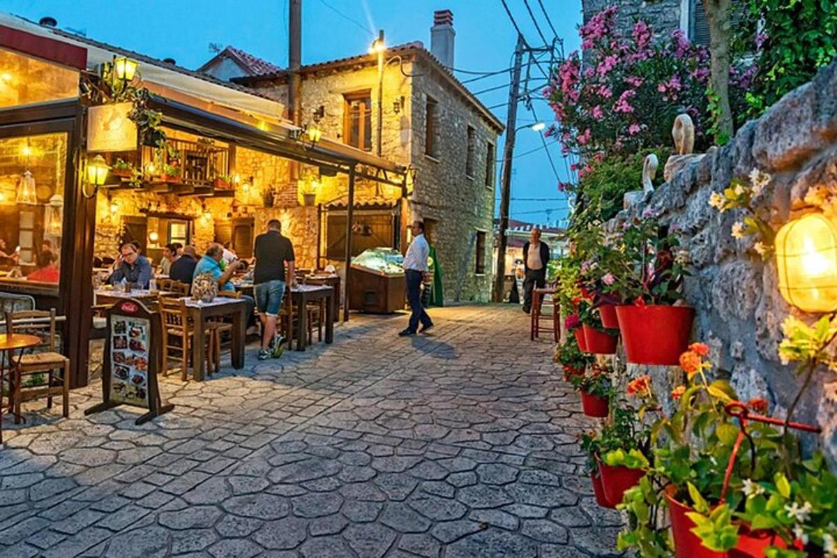 Una calle con gente sentada en mesas en un restaurante.