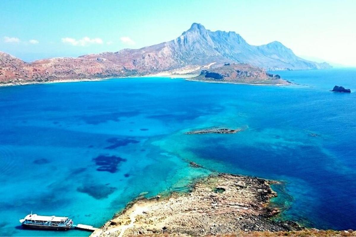 μια βάρκα σε ένα μεγάλο υδάτινο σώμα με ένα βουνό